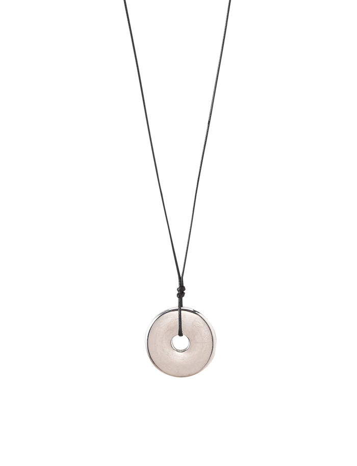 The TIGERMIST AIFE PENDANT NECKLACE - SILVER features a minimalist design with an adjustable black cord and a round, flat, translucent pendant with a central hole, shown on a plain white background.