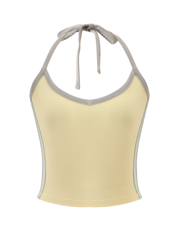 The ALYSIA TOP - BUTTER by TIGERMIST is a sleeveless, light yellow halter neck with a v-neckline, grey contrast binding stripes, and a tie at the neck, shown on a plain white background.