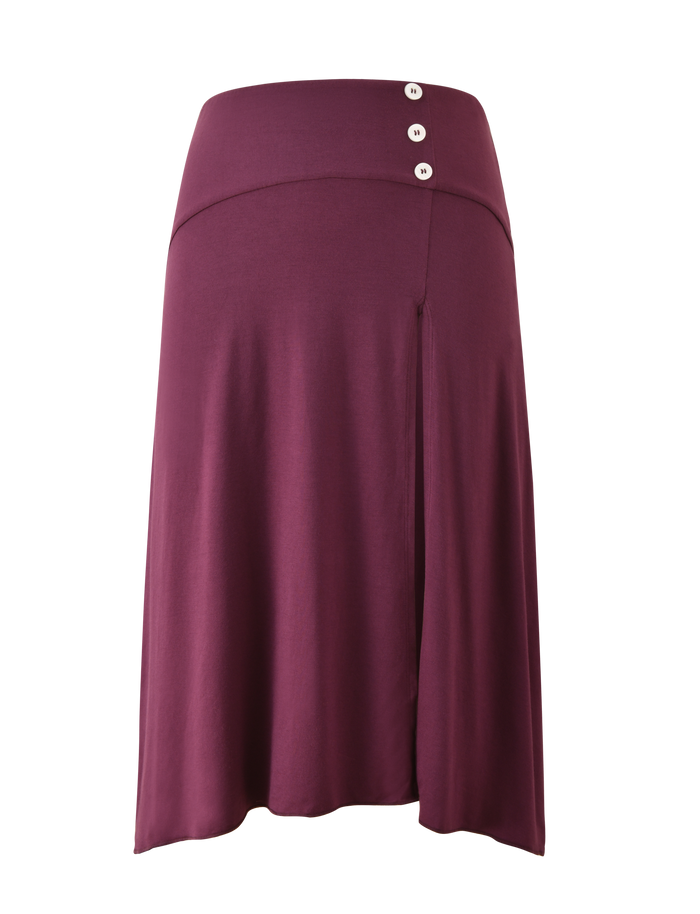 The TIGERMIST ALYSSA HI LO SKIRT in plum is a knee-length midi with a wide waistband, three white buttons on the top right, a front leg slit, and is crafted from soft, stretchy fabric.