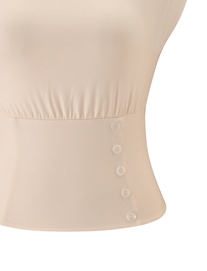 Close-up of the TIGERMIST ALYSSA OFF SHOULDER TOP in cream, highlighting the corseted waist, elastic waistband, and a row of five small white buttons on one side.