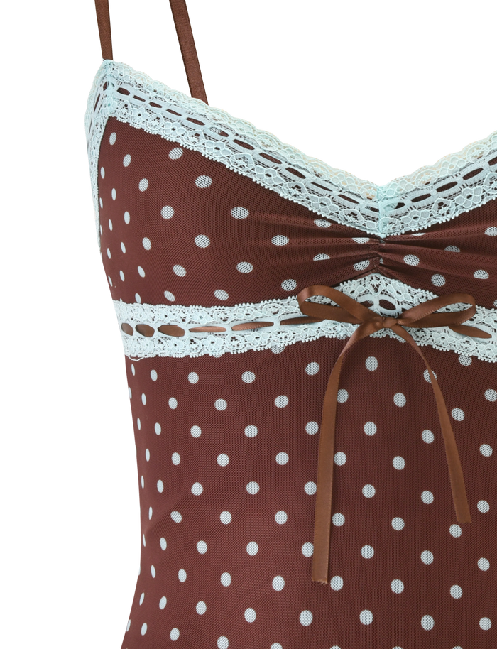 Close-up of the TIGERMIST AMARA TOP - POLKA DOT: a brown cami with thin straps, light blue lace trim on the neckline and underbust, and a small brown ribbon bow at the center front.