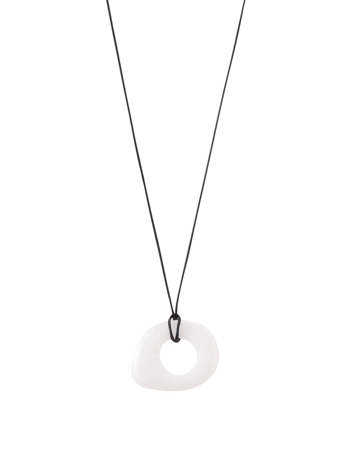 The AMYRA PENDANT NECKLACE - WHITE by TIGERMIST features a minimalist black waxed cord and an asymmetrical white resin pendant with a central hole, showcased on a plain white background.