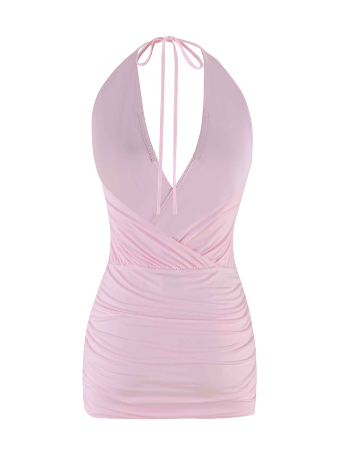 The ANABELLE MINI DRESS in baby pink by TIGERMIST features a halter neck, deep V neckline, ruched sides, and wrap-style front with an open back and thin neck-tie straps, displayed on a plain white background.