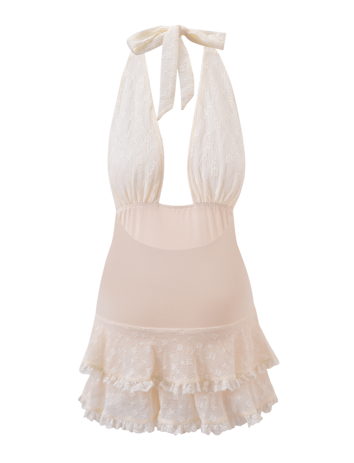 The ANOUK RUFFLE MINI DRESS by TIGERMIST is a cream halter mini with lace accents, open back, ruffled tiered skirt, gathered fabric top, and elegant neck ties for a playful yet classic look.