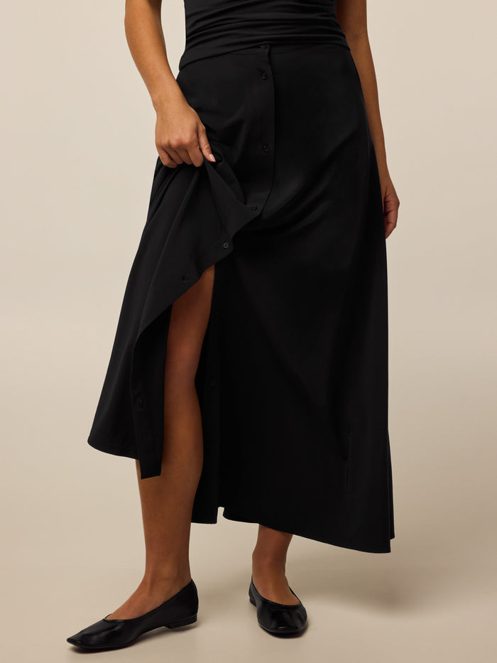 Greyson Clothiers Ashe Midi Skirt in Black - Button-Front Detail, Model Lifting Hem | Greyson Clothiers