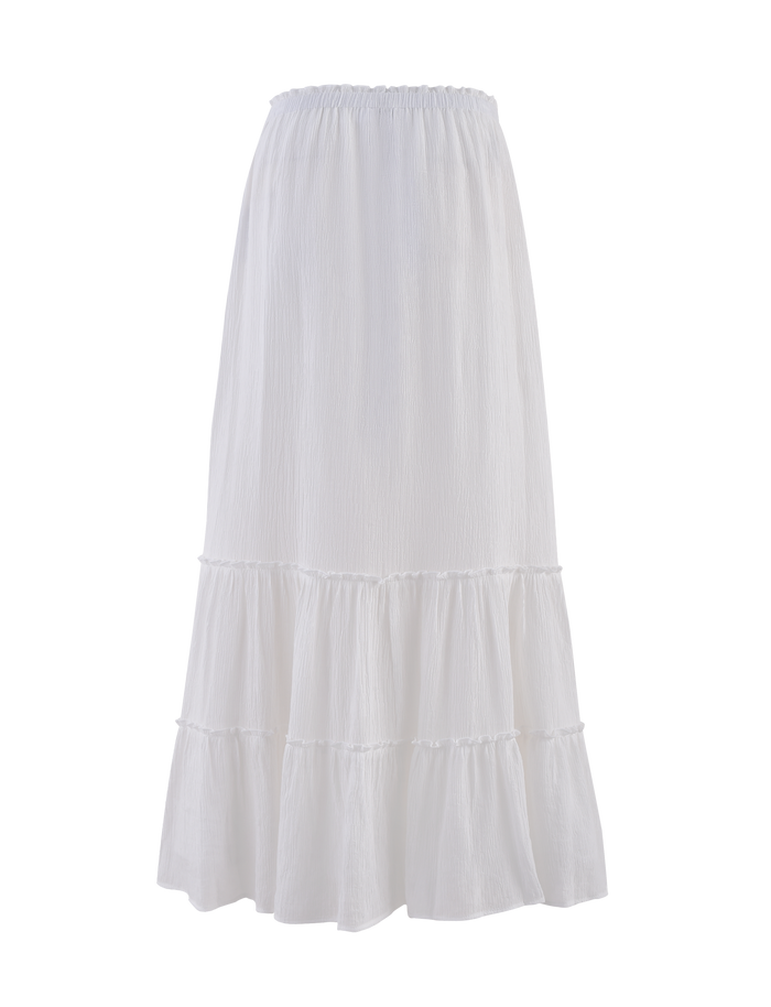 The ASHLYNN MAXI SKIRT by TIGERMIST is a white tiered maxi skirt with an elasticated waist, flowy lightweight fabric, and a contrast satin bow trim.