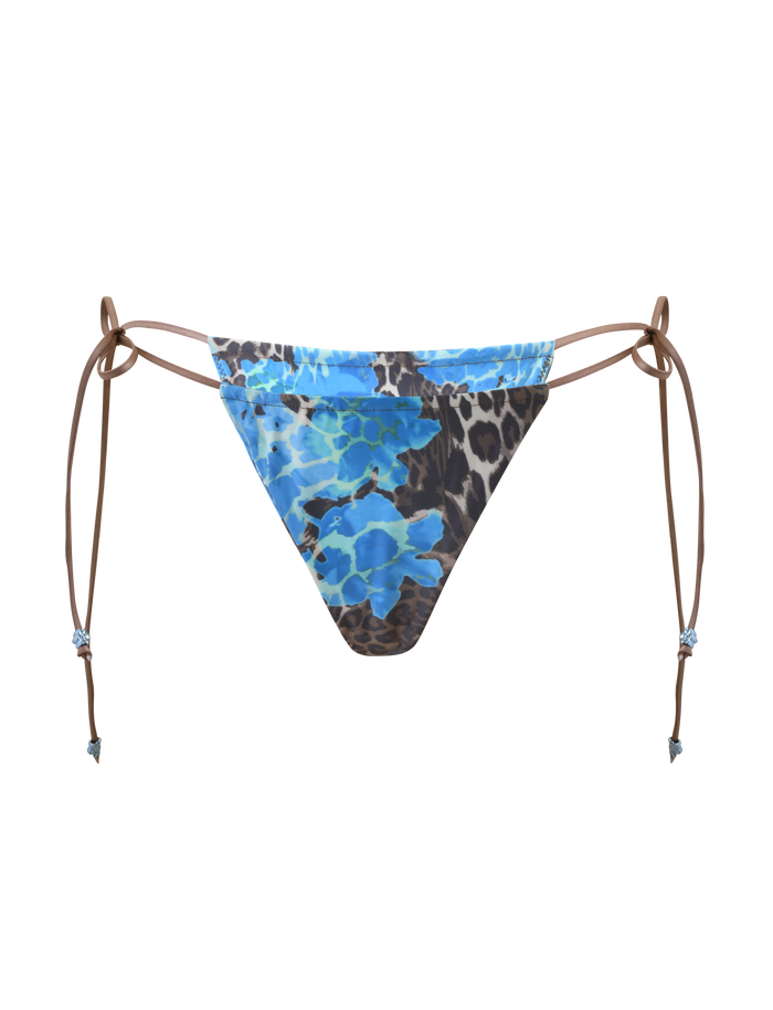 The AVE BIKINI BOTTOM - BLUE LEOPARD by TIGERMIST is a low-rise style with brown adjustable side ties, showcasing a bold blue and black leopard print on white.