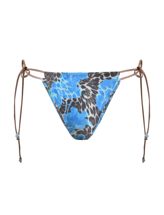 The AVE BIKINI BOTTOM - BLUE LEOPARD by TIGERMIST features brown adjustable side ties, a bold animal print, and a low-rise fit, shown on a plain white background.