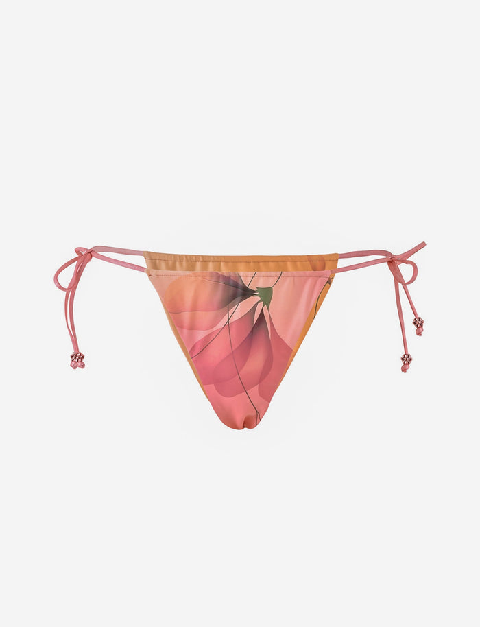 The AVE BIKINI BOTTOM - PINK : MACRO FLORAL by TIGERMIST features a cheeky cut, pink macro floral print, and adjustable side ties with decorative knots, shown on a plain white background.