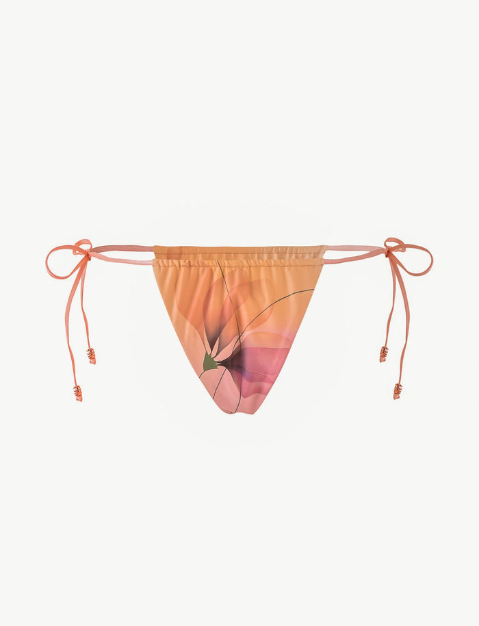 The TIGERMIST AVE BIKINI BOTTOM - PINK : MACRO FLORAL is a peach-toned cheeky bikini bottom with a pink macro floral print and adjustable beaded side ties, shown on a plain white background.