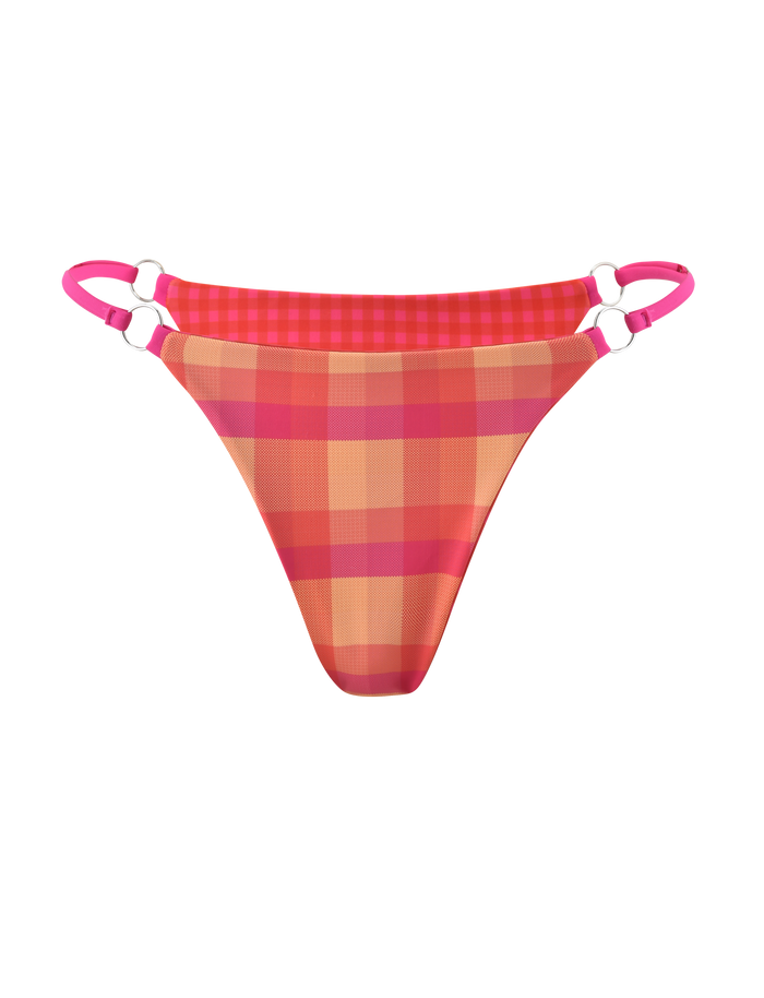 The TIGERMIST AYANNA REVERSIBLE BIKINI BOTTOM in GINGHAM AND RESORT PLAID has pink and orange plaid, double pink side straps with silver rings, cheeky coverage, and is shown on a plain white background.