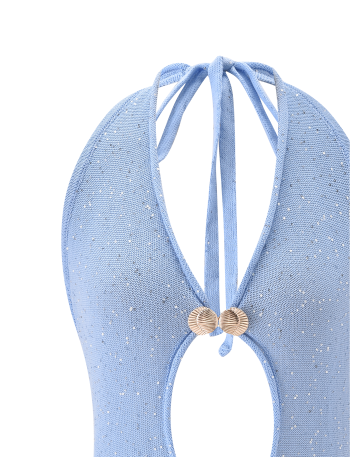 Close-up of the TIGERMIST AZURA TOP - BLUE: a light blue, sparkly swimsuit top with an open back, glitter halter ties, and gold shell embellishments at the center.
