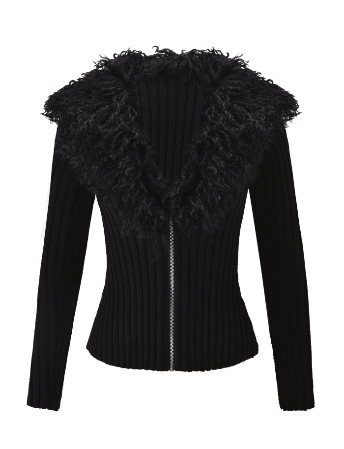 The BRISA JUMPER by TIGERMIST is a black, long-sleeve ribbed cardigan featuring a large faux fur collar, fitted silhouette, and sleek silver zipper, shown against a white background.