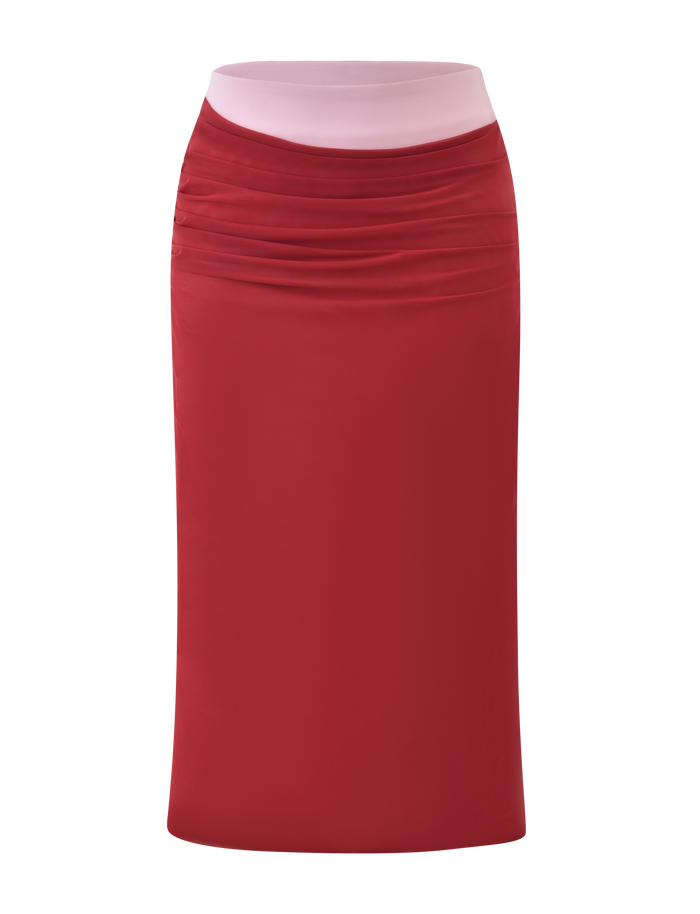 The CALINE MIDI SKIRT - RED by TIGERMIST is a knee-length, color block midi skirt with gentle ruching at the top and a contrasting light pink waistband, shown against a white background.