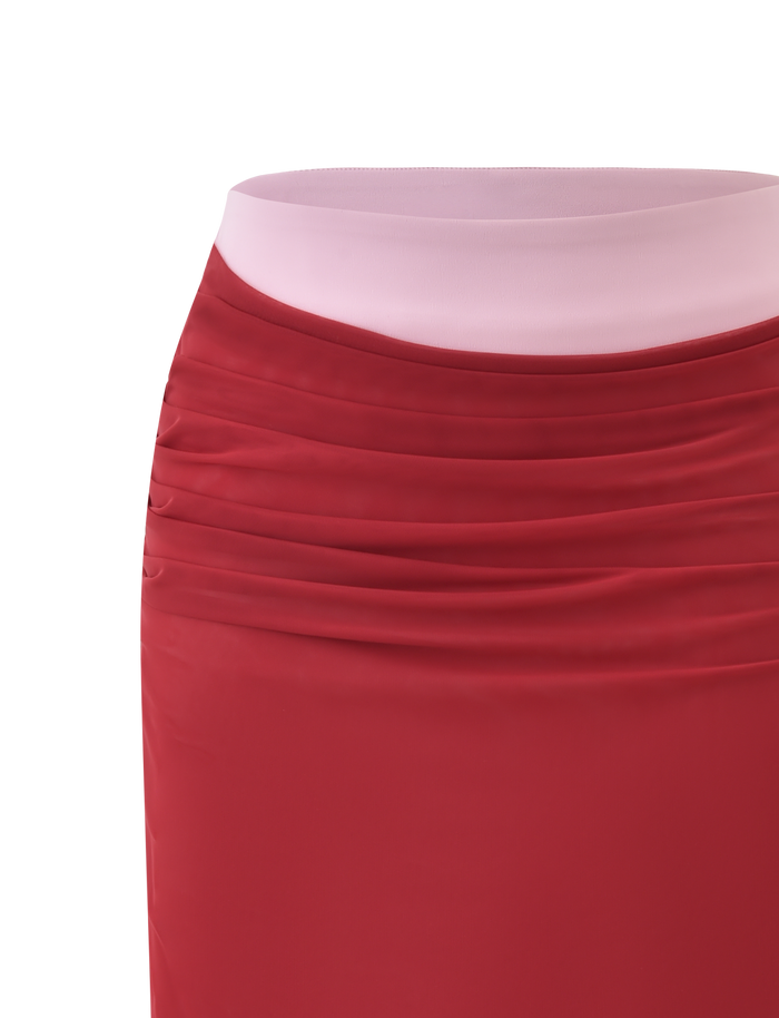 Close-up of the CALINE MIDI SKIRT - RED by TIGERMIST, featuring sheer red mesh fabric with gathered ruching near the light pink waistband, displayed against a white background.