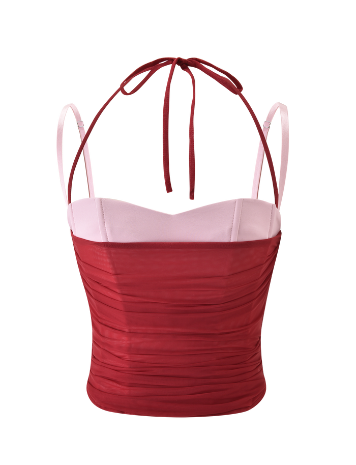 The CALINE RUCHED CORSET by TIGERMIST is a sleeveless, fitted crop top with a sweetheart neckline, light pink cups, ruched red bodice, and thin red halter neck ties, displayed on a plain white background.