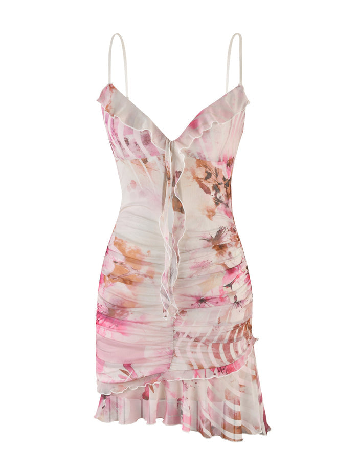 The Tiger Mist Carly Dress in a floral multi-color design showcases thin spaghetti straps and features a fitted bodice with vertical ruching. It has a V-neckline adorned with ruffles, extending to an asymmetrical hem with additional ruffle details.