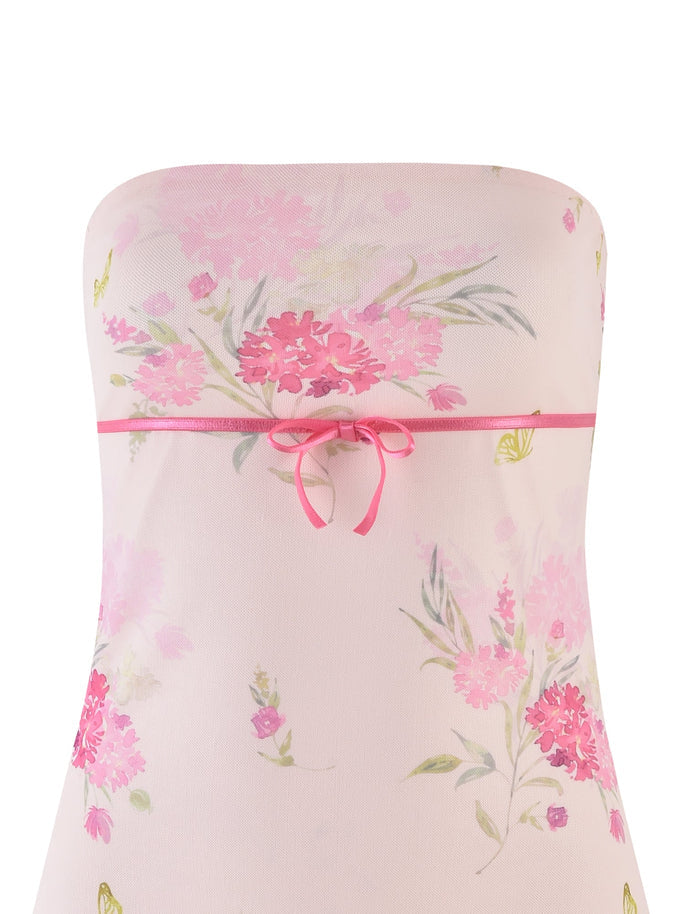 The CARSYN MINI DRESS by TIGERMIST features a strapless neckline with a watercolor floral print of pink flowers and green leaves, accented by an elegant ribbon bow at the chest.