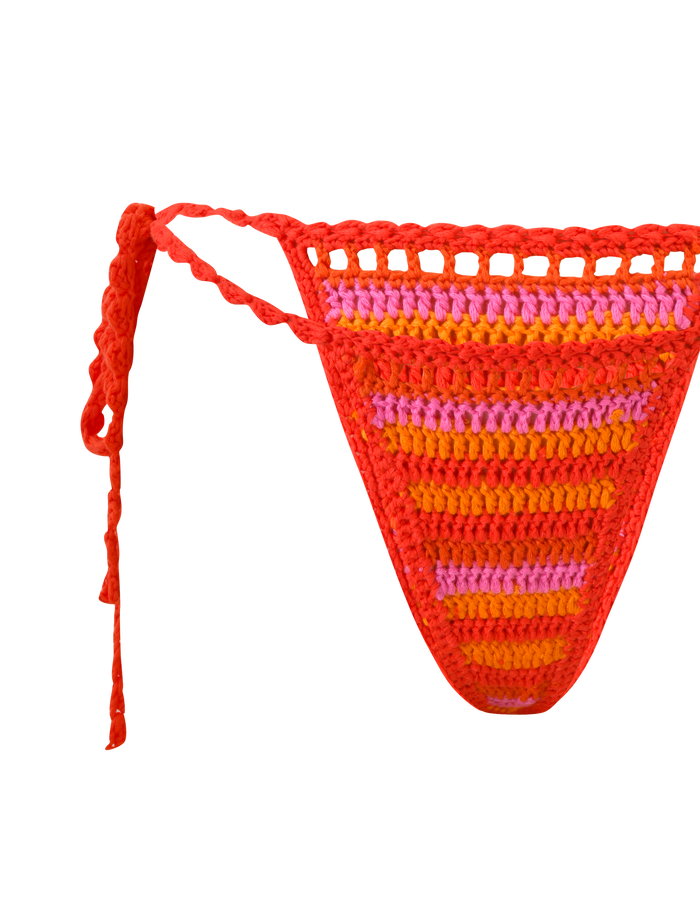 The TIGERMIST CORA BIKINI BOTTOM - SUNSET TROPICAL STRIPE features multicolour red, orange, and pink crochet stripes with side ties. This cheeky style adds a playful touch to your swimwear collection. Shown against a white background.