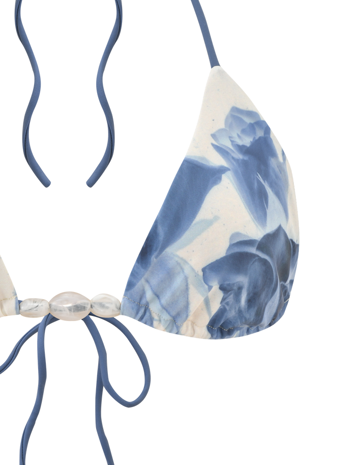 A close-up of the TIGERMIST CYLAS BIKINI TOP - INDIGO FLORAL, featuring adjustable triangle cups with blue floral prints, halter neck ties, and clear bead accents.