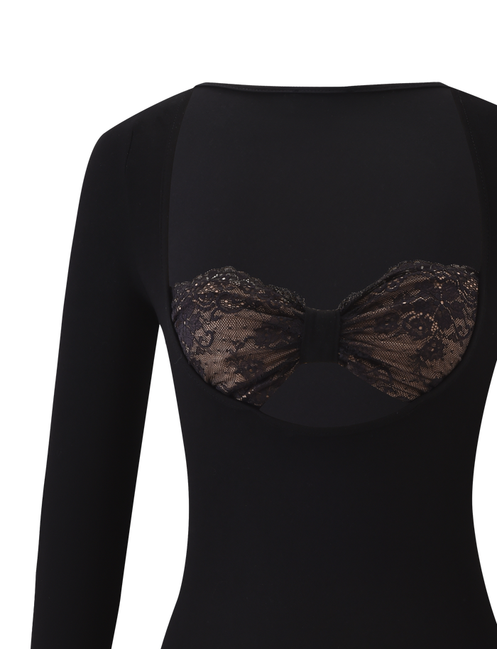 A close-up of the DAMELA LONG SLEEVE TOP - BLACK by TIGERMIST shows a large back cutout revealing a floral lace bandeau with center detailing underneath.