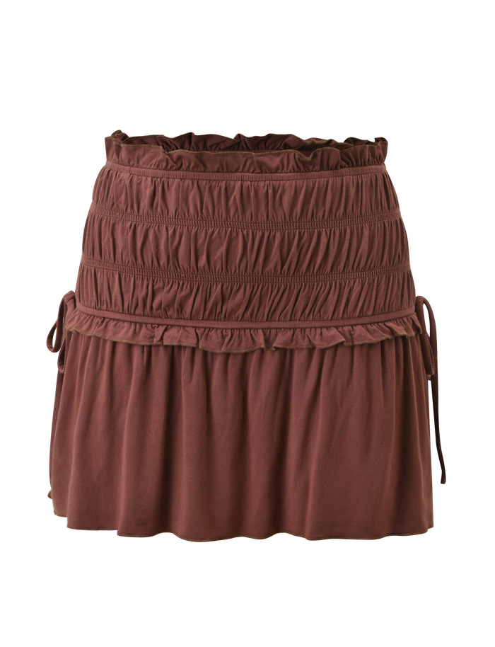 The TIGERMIST DENALI MINI SKIRT - CHOCOLATE features a wide shirred waistband, ruched detailing, ruffled trim, and drawstring ties on each side, shown against a white background.