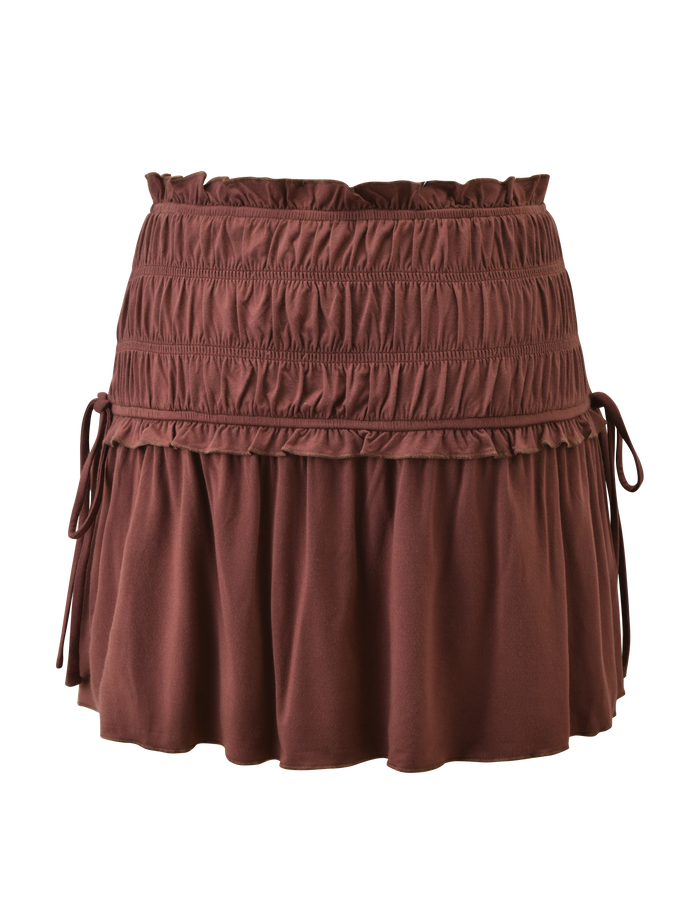 The TIGERMIST DENALI MINI SKIRT - CHOCOLATE features a wide shirred waistband, decorative stitching, adjustable side ties, and a flared ruffled hem.