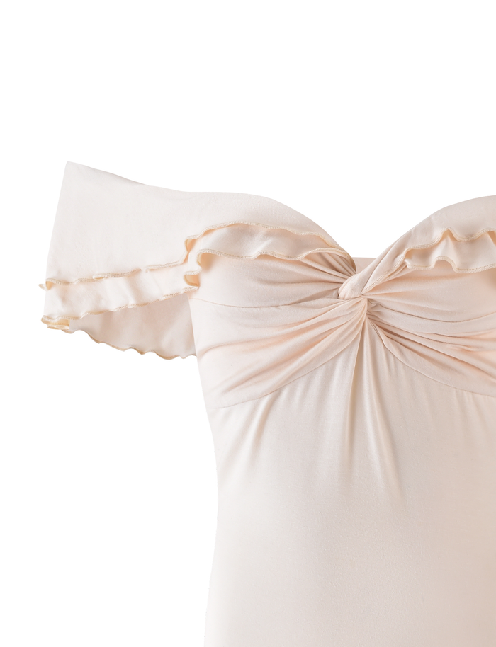 The DENALI TOP in Bone by TIGERMIST is an off-the-shoulder neutral top made from buttery jersey, featuring ruffled short sleeves and a gathered twist at the neckline, shown against a white background.