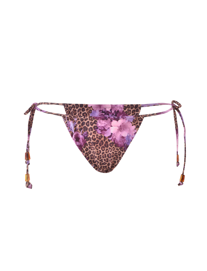 The TIGERMIST DESIRAE BIKINI BOTTOM - PURPLE : FLORAL : FLORAL LEOPARD is a fully lined bikini bottom with floral leopard print and adjustable side ties, finished with small brown beads.