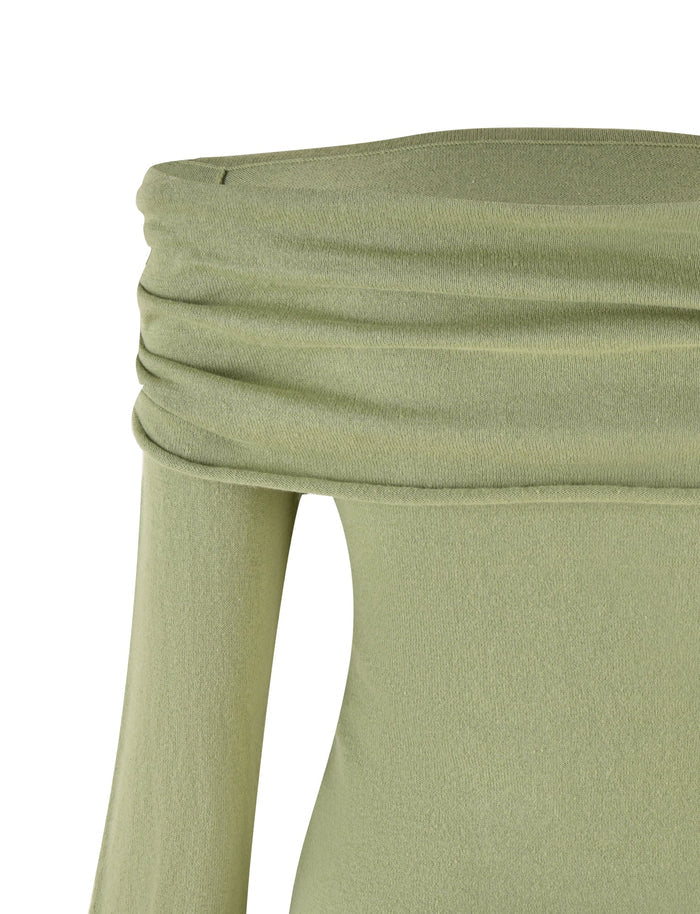 The image showcases a close-up view of the DIEDRE JUMPER - GREEN by TIGERMIST. The fabric, made of high stretch cotton, has a slightly textured, stretchy appearance and features a folded-over edge at the off-the-shoulder neckline. No other parts of the garment or background are visible.