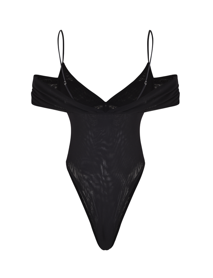 The DRAYA BODYSUIT by TIGERMIST is a black, off-shoulder mesh bodysuit featuring thin spaghetti straps, a ruched bust detail, and high-cut legs, shown on a plain white background.