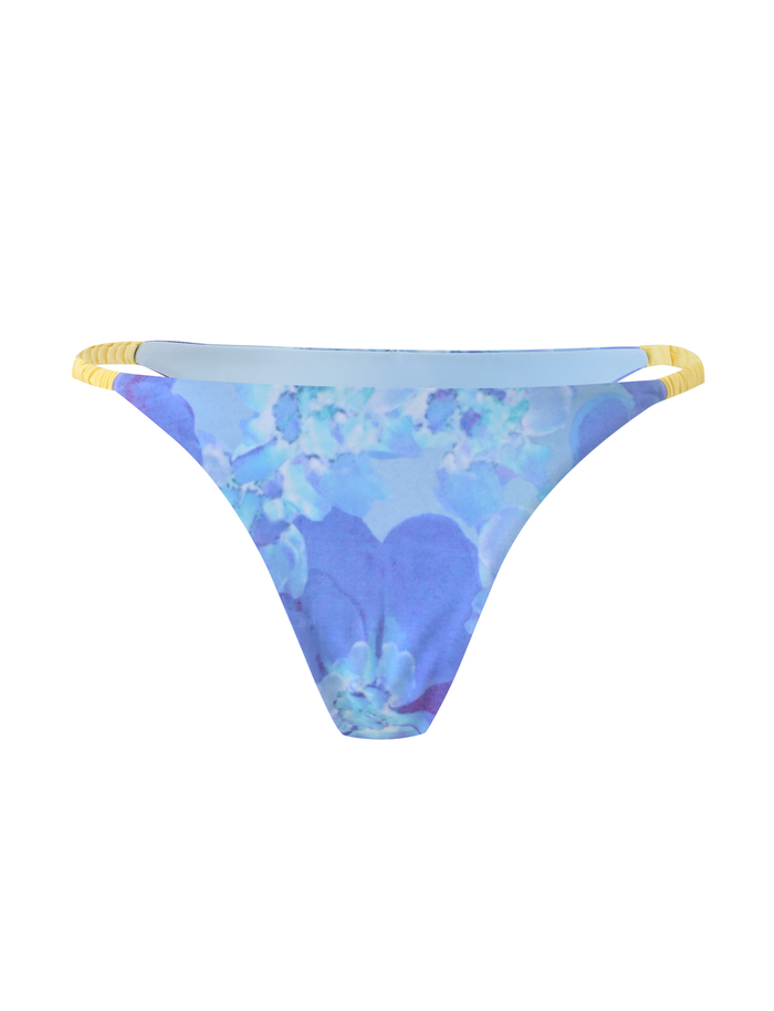 The TIGERMIST EMBERLAIN BIKINI BOTTOM - BLUE MACRO FLORAL features a vibrant blue floral print and thin yellow elasticated hip straps, shown against a white background.