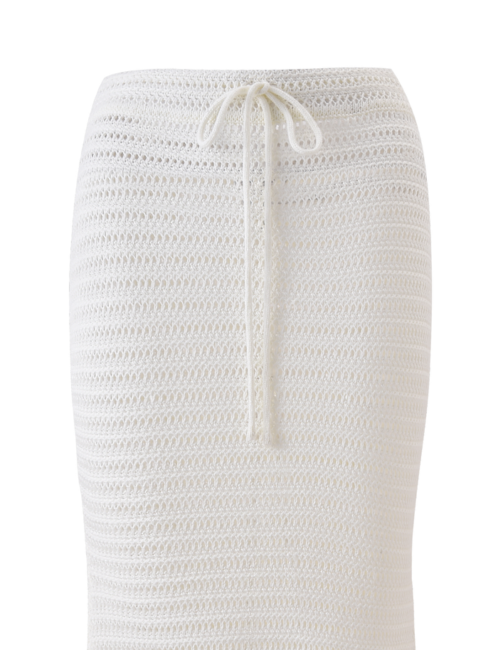 A close-up of the TIGERMIST EMELYN MIDI SKIRT in cream, a white semi-sheer crochet skirt featuring an elasticated waist and drawstring tie, shown against a plain white background.