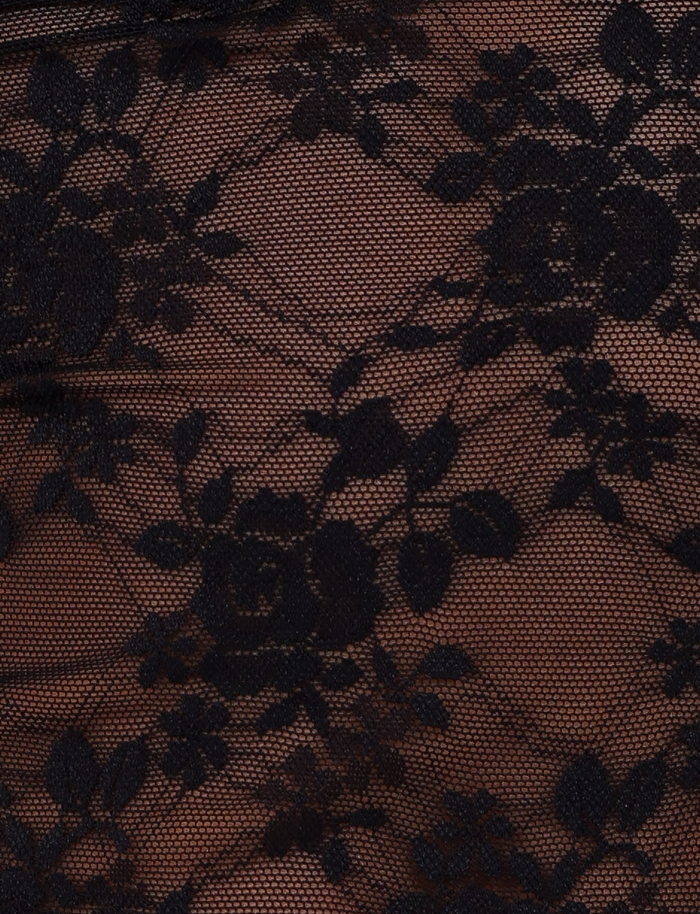 Close-up of EMERI TOP - BLACK by TIGERMIST, featuring intricate black floral lace with flowers and leaves on a sheer light brown base—ideal for stunning cutout details or a chic waist panel on this bodycon fit top.