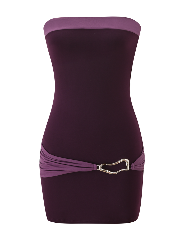The EOS MINI DRESS by TIGERMIST features a strapless, form-fitting silhouette in aubergine and iris tones, color-blocked with a darker bodice, lighter waistband, and a metallic abstract buckle accent at the hip.