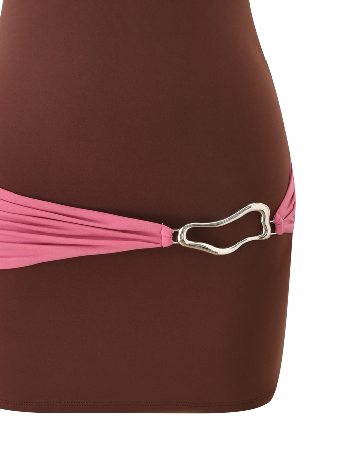 A close-up of the TIGERMIST EOS MINI DRESS in espresso and rose, featuring colour blocking and a pink fabric belt with a silver, irregular-shaped buckle at the waist.