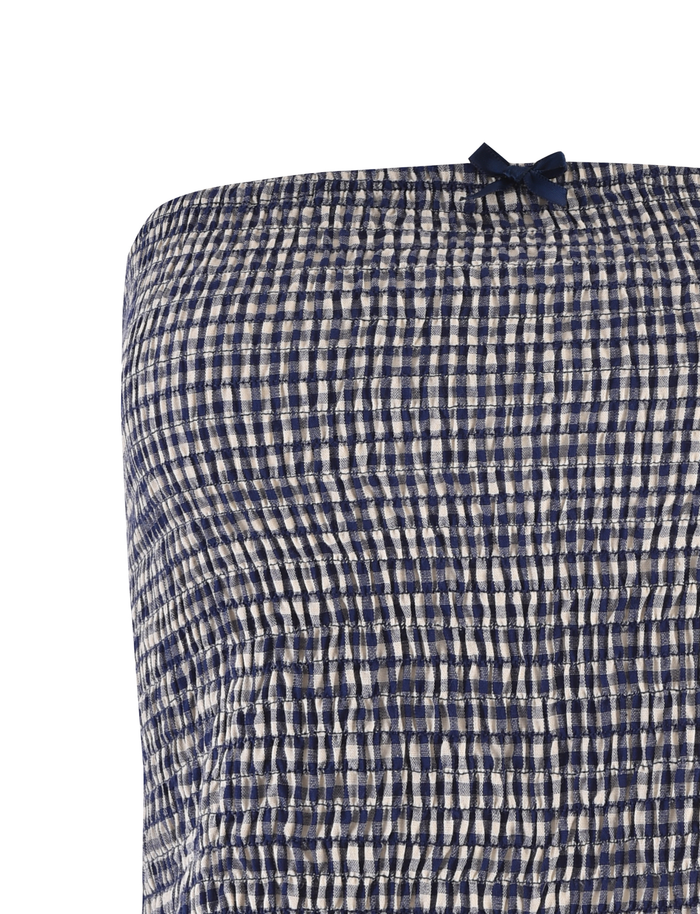 Close-up of the TIGERMIST ERYNN TOP in navy gingham, showcasing smocked, crinkled checkered fabric with a dark blue bow at the top center and a flattering bodycon fit.