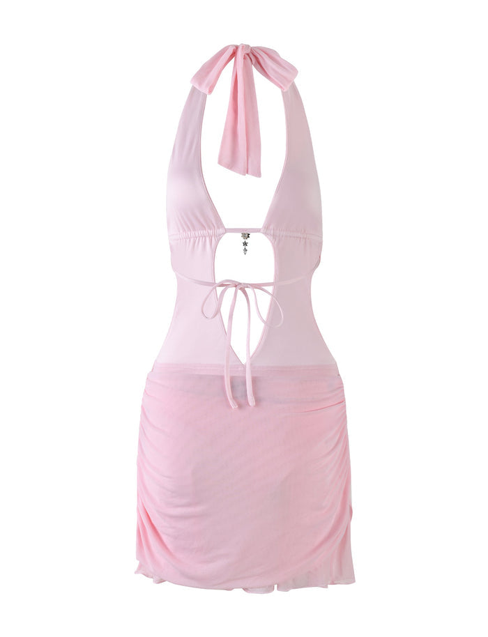 The ESHA DRESS - PINK by TIGERMIST is a baby pink mini dress with a halter neck, deep V neckline, tie-back straps, front cutout and tie detail, ruched skirt, and lightweight fabric for a flirty look.