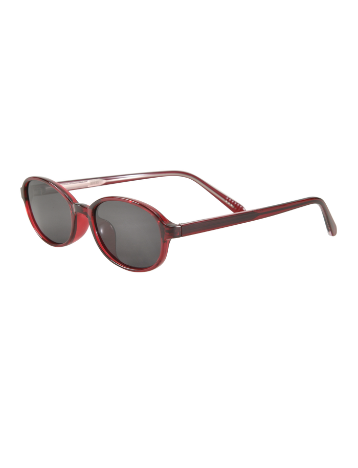 ESTA GLASSES - RED by TIGERMIST: Red-framed oval fashion sunglasses with dark tinted UV400 lenses. Displayed on a white background at an angle, showing both the front and side of the frames.
