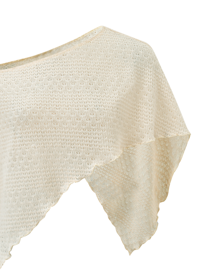 Close-up of the TIGERMIST FAIRLEE PONCHO in cream, featuring a crochet knit with a textured pattern and uneven hem, displayed on a plain white background.