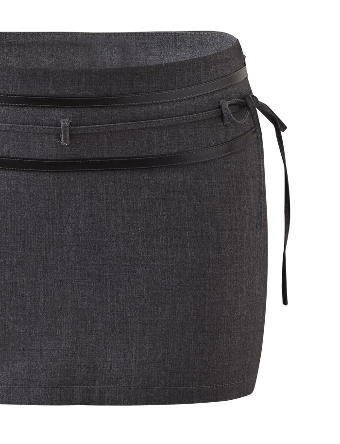 The FEDRA SKORT - GREY by TIGERMIST is a dark gray, knee-length skort with subtle texture, black trim, leather accents, and a thin black belt tied in a small side bow.