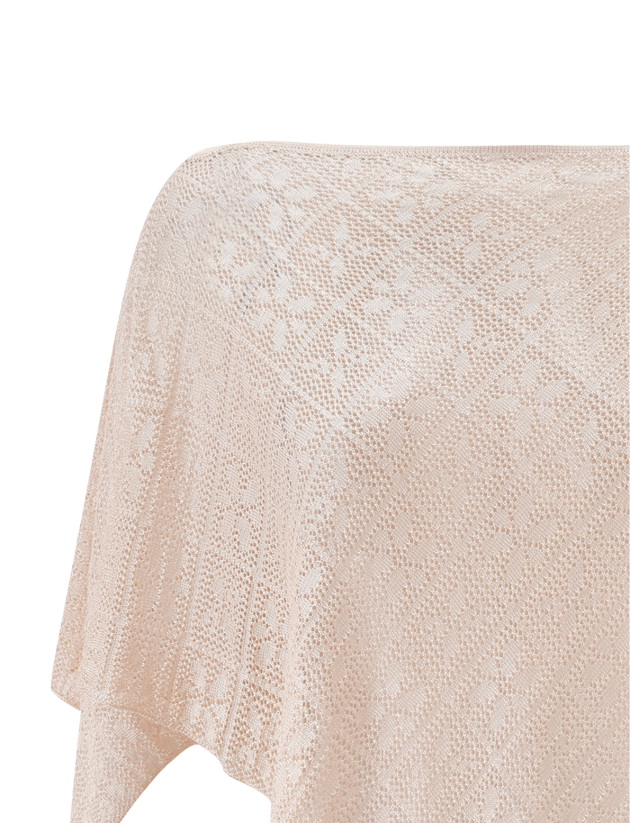A close-up of the TIGERMIST FERN CROCHET PONCHO in champagne, featuring light beige semi-sheer knit with a delicate floral pattern on a plain white background—ideal as a chic beach cover up or festival wear.