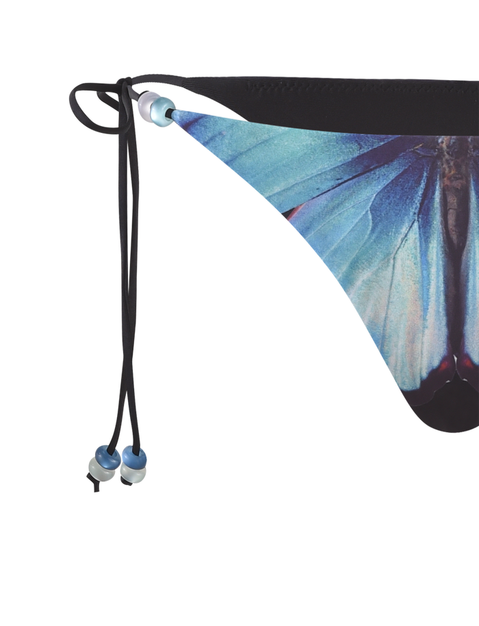 Close-up of the TIGERMIST FINLEA BIKINI BOTTOM - BLACK : BUTTERFLY, featuring a blue wing butterfly print, black side drawstring ties, and a cheeky bikini cut.