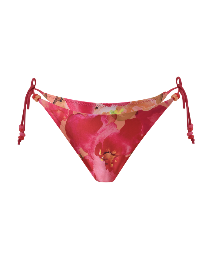 The FINLEA BIKINI BOTTOM - DAIQUIRI FLORAL by TIGERMIST is a cheeky bikini brief with adjustable side ties, showcasing a vibrant pink floral pattern with red accents on a white background.
