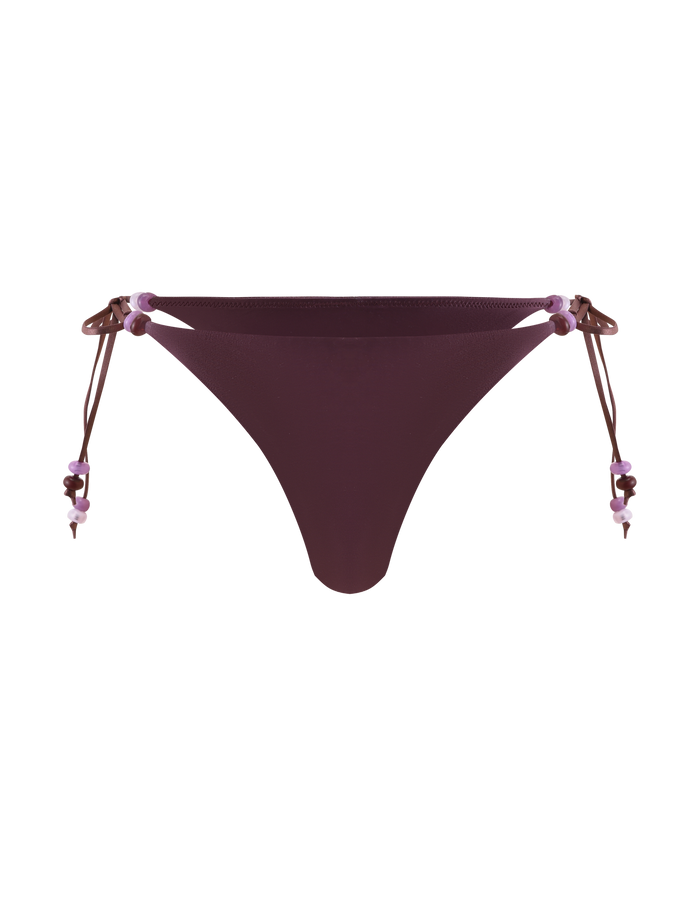The TIGERMIST FINLEA BIKINI BOTTOM - ZEN FLORAL features a maroon cheeky cut with side ties and purple beaded straps, shown on a plain white background.