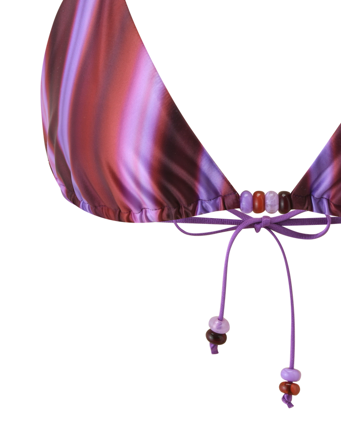 Close-up of the TIGERMIST FINLEA BIKINI TOP - DUSK OMBRE STRIPE in purple and pink gradients, featuring an adjustable triangle shape and drawstring tie with small purple and red beads.