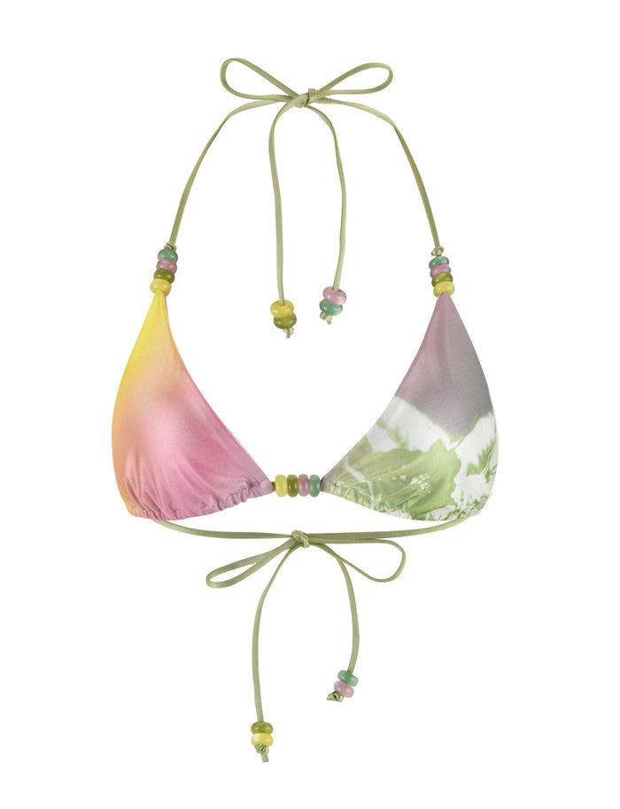 The FINLEA Bikini Top from TIGERMIST is a vibrant and stylish piece featuring a halter neck and back tie design. The fabric displays a gradient design with hues of green, pink, yellow, and purple, complemented by subtle tropical floral print accents. Decorative beads in green, pink, and yellow adorn the ends of the ties as well as along the strings.