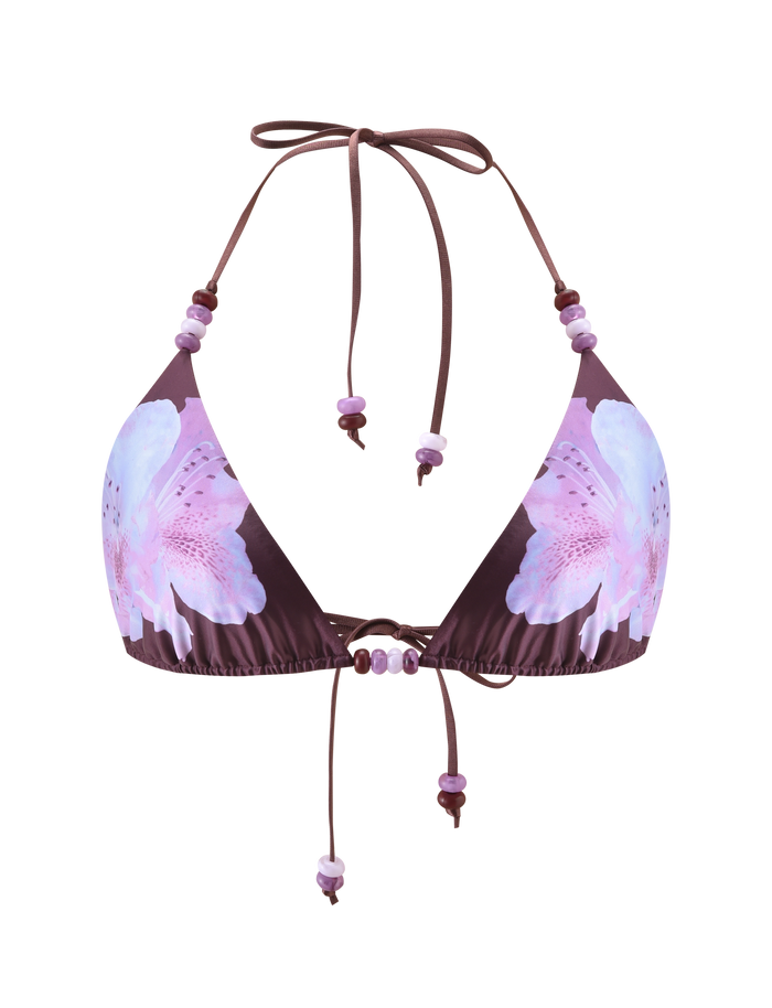 The FINLEA BIKINI TOP - ZEN FLORAL by TIGERMIST features a brown triangle shape, pink and light blue floral print, adjustable halter neck and back ties, and purple bead accents on the strings.
