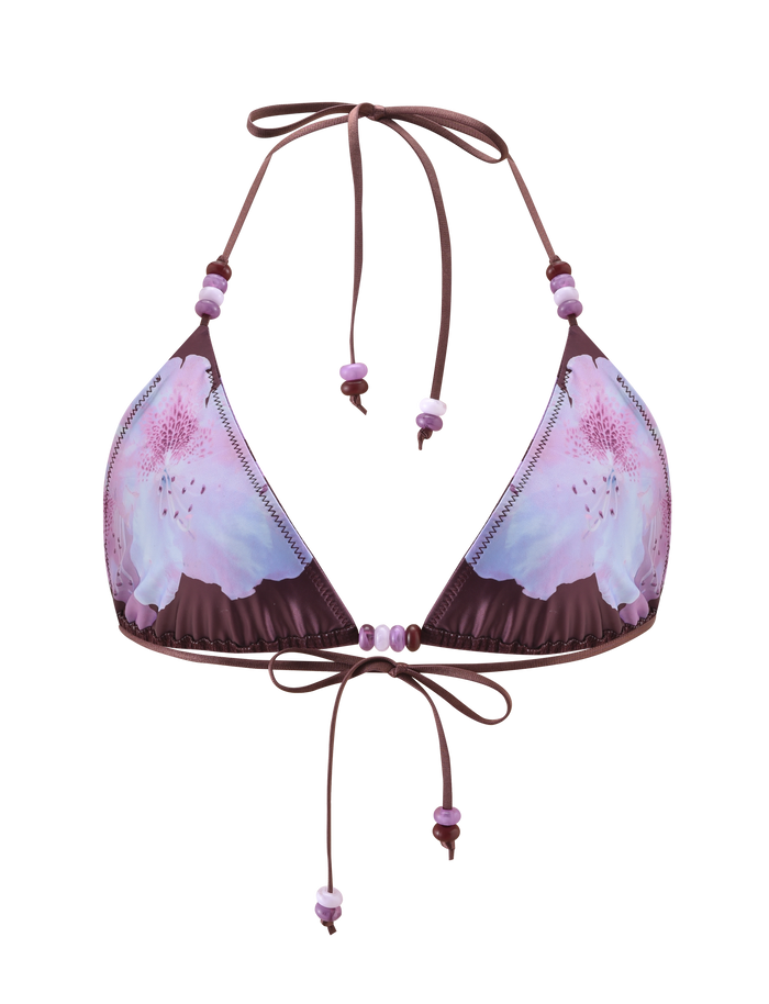 The FINLEA BIKINI TOP - ZEN FLORAL by TIGERMIST features a purple and pink floral print, triangle cups, halter neck ties at neck and back, and decorative matching beads on the string ties.