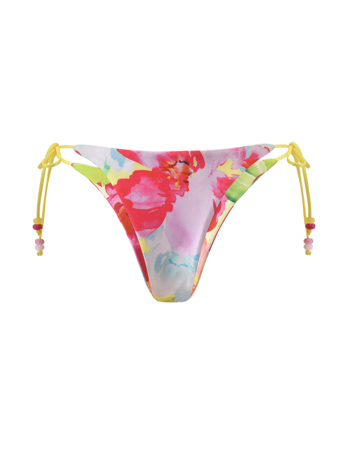 The TIGERMIST FINLEA REVERSIBLE BIKINI BOTTOM - GARDEN DAIQUIRI FLORAL features a cheeky fit, colorful red, pink, and green floral print, and yellow side string ties with beaded accents, shown on a white background.